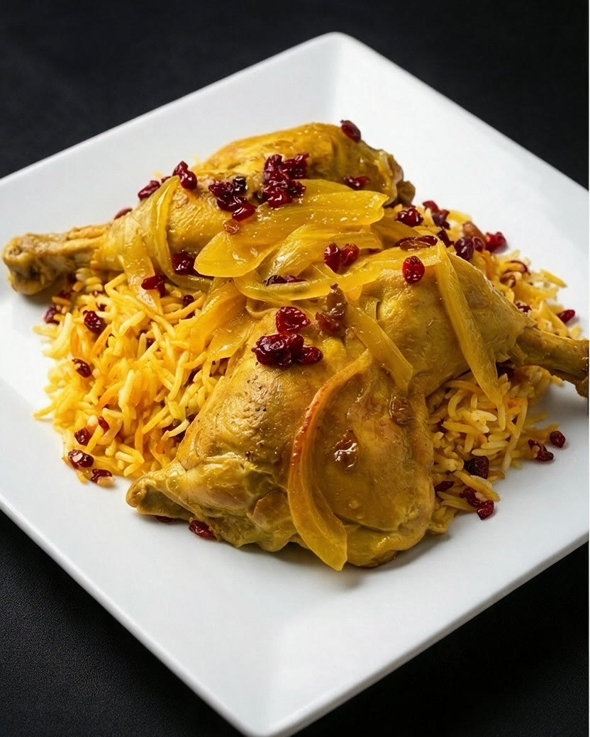 Slow roasted saffron chicken over barberry saffron rice on a white plate